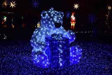 Noel hediyelerini koruyan mavi bir ayı.