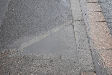 Sokakta çatlaklar olan asfalt bir yol..