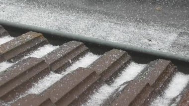 Buz fırtınası, dik bir çatıda buz topakları biriktiriyor.