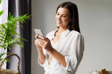 İş kadını akıllı telefondan mesaj yazıyor. Kız iş için cep telefonu kullanıyor, müşterileri arıyor, mesajlar gönderiyor.