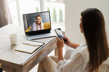 Millennial kızı dizüstü bilgisayarda oturup uzaktan çalışıyor. Öğrenci çevrimiçi uzaklık öğrenme fırsatlarını kullanır. 