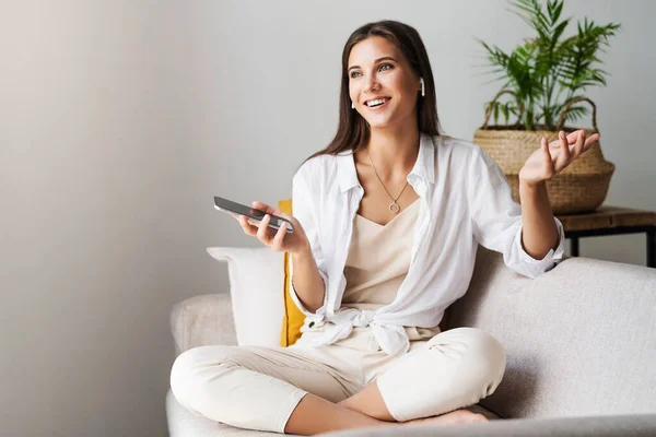 Female relaxing at home, using smartphone to text messages, share photos, communicate with friends, check email — Stock Photo, Image