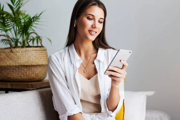 Kadın evde dinleniyor, akıllı telefonu mesajlarda kullanıyor, fotoğrafları paylaşıyor, arkadaşlarıyla iletişim kuruyor.