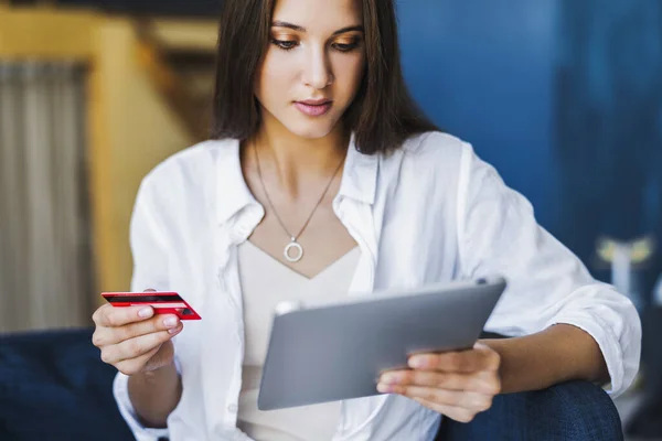 Female using bank card to pay for goods purchased online.