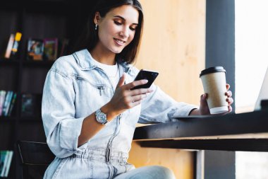 Çekici iş kadını dizüstü bilgisayarın önünde oturuyor ve cep telefonuyla konuşuyor, telefonda görüşüyor.. 