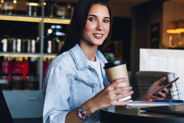 Çekici iş kadını dizüstü bilgisayarın önünde oturuyor ve cep telefonuyla konuşuyor, telefonda görüşüyor.. 