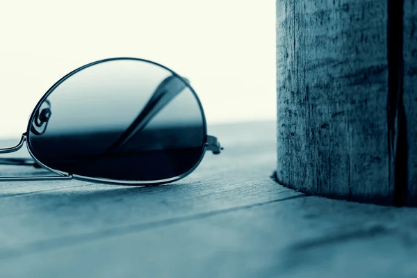 Occhiali da sole specchiati Dettaglio sullo sfondo in legno Close Up e Focus selettivo. Concetto di moda in ciano . — Foto Stock