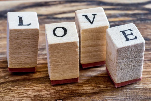 Amor conceito feliz Dia dos Namorados. Carimbo de amor no fundo do bosque vintage. Palavra de amor Escrito em blocos de madeira . — Fotografia de Stock
