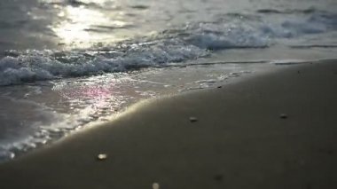 Nirvana sahilde - denize, altın bir gün batımının huzurlu pastoral sahne yavaş yavaş kum üzerine sıçramasına dalgalar. Sakin deniz alacakaranlıkta portre. Deniz suyu güneş yansıması. Doğa arka plan.