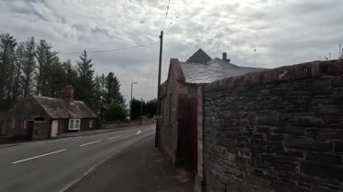 Traditional stone-built houses and commercial buildings lining the main street in Lauder town center Scottish Borders featuring pitched slate roofs, timber-framed windows, colorful doors, and views to town hall clock tower