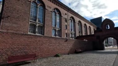 Urban scene in Copenhagen city centre captures Nyhavn canal lined with 17th century buildings, bicycles parked along the waterfront, and people strolling in the afternoon light