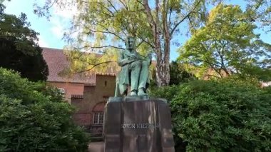 Urban scene in Copenhagen city centre captures Nyhavn canal lined with 17th century buildings, bicycles parked along the waterfront, and people strolling in the afternoon light