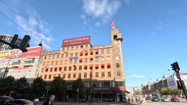 Urban scene in Copenhagen city centre captures Nyhavn canal lined with 17th century buildings, bicycles parked along the waterfront, and people strolling in the afternoon light