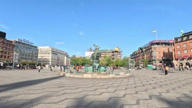 Urban scene in Copenhagen city centre captures Nyhavn canal lined with 17th century buildings, bicycles parked along the waterfront, and people strolling in the afternoon light