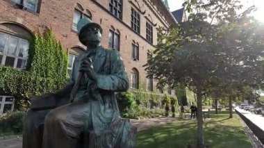 Urban scene in Copenhagen city centre captures Nyhavn canal lined with 17th century buildings, bicycles parked along the waterfront, and people strolling in the afternoon light
