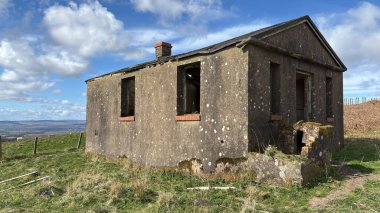 Countryside landscape near Milquhanzie Hill in Perth and Kinross Scotland showing ridge summit with masts, walking paths, and nearby ancient standing stones.