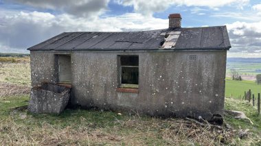 Countryside landscape near Milquhanzie Hill in Perth and Kinross Scotland showing ridge summit with masts, walking paths, and nearby ancient standing stones.