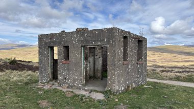 Countryside landscape near Milquhanzie Hill in Perth and Kinross Scotland showing ridge summit with masts, walking paths, and nearby ancient standing stones.