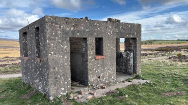 Countryside landscape near Milquhanzie Hill in Perth and Kinross Scotland showing ridge summit with masts, walking paths, and nearby ancient standing stones.
