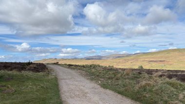Countryside landscape near Milquhanzie Hill in Perth and Kinross Scotland showing ridge summit with masts, walking paths, and nearby ancient standing stones.