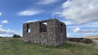 Countryside landscape near Milquhanzie Hill in Perth and Kinross Scotland showing ridge summit with masts, walking paths, and nearby ancient standing stones.