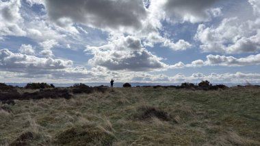 Countryside landscape near Milquhanzie Hill in Perth and Kinross Scotland showing ridge summit with masts, walking paths, and nearby ancient standing stones.