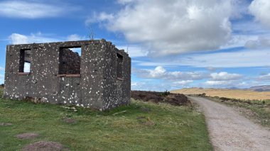 Countryside landscape near Milquhanzie Hill in Perth and Kinross Scotland showing ridge summit with masts, walking paths, and nearby ancient standing stones.