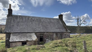 Countryside landscape near Milquhanzie Hill in Perth and Kinross Scotland showing ridge summit with masts, walking paths, and nearby ancient standing stones.