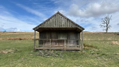 Countryside landscape near Milquhanzie Hill in Perth and Kinross Scotland showing ridge summit with masts, walking paths, and nearby ancient standing stones.