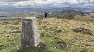 Countryside landscape near Milquhanzie Hill in Perth and Kinross Scotland showing ridge summit with masts, walking paths, and nearby ancient standing stones.