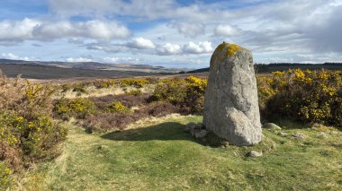 Countryside landscape near Milquhanzie Hill in Perth and Kinross Scotland showing ridge summit with masts, walking paths, and nearby ancient standing stones.