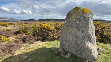 Countryside landscape near Milquhanzie Hill in Perth and Kinross Scotland showing ridge summit with masts, walking paths, and nearby ancient standing stones.