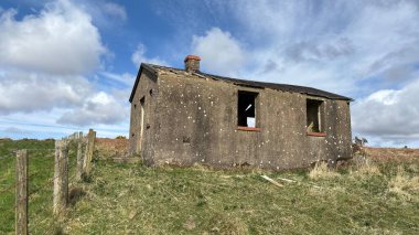Countryside landscape near Milquhanzie Hill in Perth and Kinross Scotland showing ridge summit with masts, walking paths, and nearby ancient standing stones.