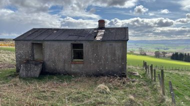 Countryside landscape near Milquhanzie Hill in Perth and Kinross Scotland showing ridge summit with masts, walking paths, and nearby ancient standing stones.
