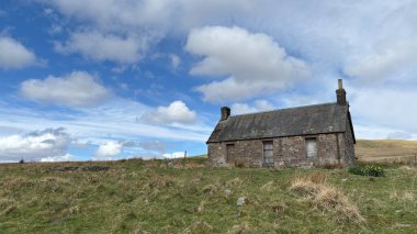 Countryside landscape near Milquhanzie Hill in Perth and Kinross Scotland showing ridge summit with masts, walking paths, and nearby ancient standing stones.