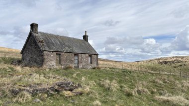 Countryside landscape near Milquhanzie Hill in Perth and Kinross Scotland showing ridge summit with masts, walking paths, and nearby ancient standing stones.