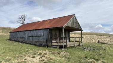 Countryside landscape near Milquhanzie Hill in Perth and Kinross Scotland showing ridge summit with masts, walking paths, and nearby ancient standing stones.