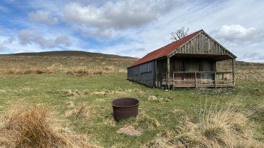 Countryside landscape near Milquhanzie Hill in Perth and Kinross Scotland showing ridge summit with masts, walking paths, and nearby ancient standing stones.