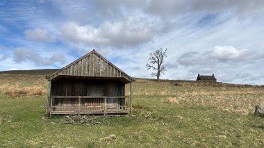 Countryside landscape near Milquhanzie Hill in Perth and Kinross Scotland showing ridge summit with masts, walking paths, and nearby ancient standing stones.