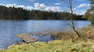 Countryside landscape near Milquhanzie Hill in Perth and Kinross Scotland showing ridge summit with masts, walking paths, and nearby ancient standing stones.