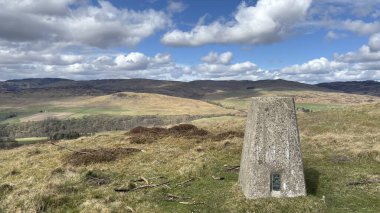 Countryside landscape near Milquhanzie Hill in Perth and Kinross Scotland showing ridge summit with masts, walking paths, and nearby ancient standing stones.