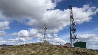 Countryside landscape near Milquhanzie Hill in Perth and Kinross Scotland showing ridge summit with masts, walking paths, and nearby ancient standing stones.