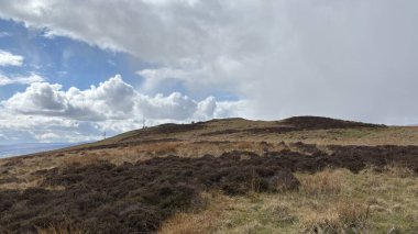 Countryside landscape near Milquhanzie Hill in Perth and Kinross Scotland showing ridge summit with masts, walking paths, and nearby ancient standing stones.