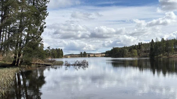 Countryside landscape near Milquhanzie Hill in Perth and Kinross Scotland showing ridge summit with masts, walking paths, and nearby ancient standing stones.