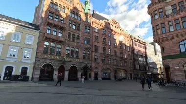 İsveç 'in başkenti Malmö' de Stortorget Meydanı, Lilla Torg, St Peters Kilisesi 1319, Belediye Binası, Malmö Şatosu ve Turning Torso Kulesi gibi çağdaş mimari yapılar da dahil olmak üzere cadde ve binaların manzarası.