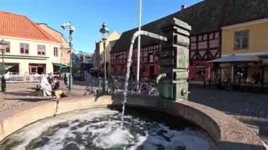İsveç 'in başkenti Malmö' de Stortorget Meydanı, Lilla Torg, St Peters Kilisesi 1319, Belediye Binası, Malmö Şatosu ve Turning Torso Kulesi gibi çağdaş mimari yapılar da dahil olmak üzere cadde ve binaların manzarası.