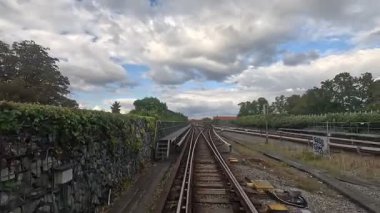 Arka planda Kopenhag mimarisi ile raylar ve şehir silueti üzerinden metro vagonuna bak.