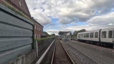 Arka planda Kopenhag mimarisi ile raylar ve şehir silueti üzerinden metro vagonuna bak.