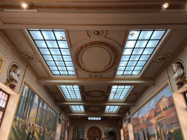 Внутри Капитолия Тулузы, исторической ратуши города, с неоклассической архитектурой с мраморными лестницами, фресковыми потолками и элегантными церемониальными залами.