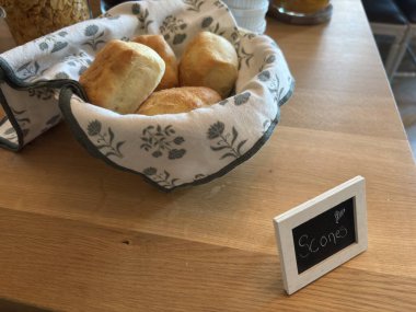 İsveç 'te kırsal bir masada sade ve meyve çeşitleri de dahil olmak üzere çeşitli çöreklerle hasır ekmek sepeti, yulaf ve tatlı ya da tatlı servis için yapılan hızlı pişirilmiş İsveç çörekleri.